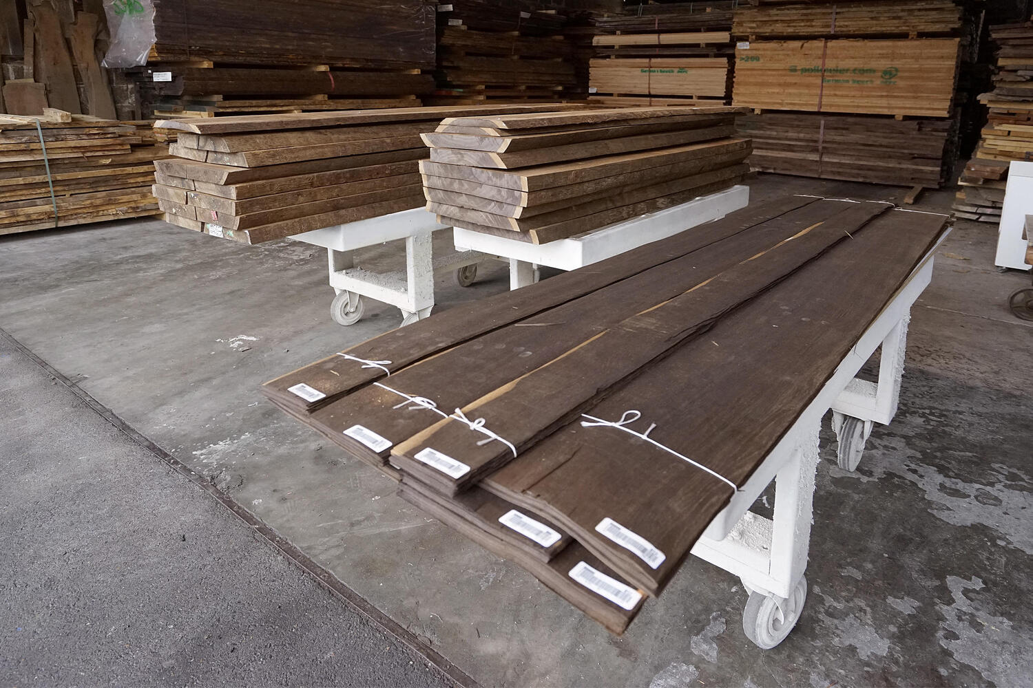 Holzbohlen auf Rollwagen im Holzlager der Schreinerei